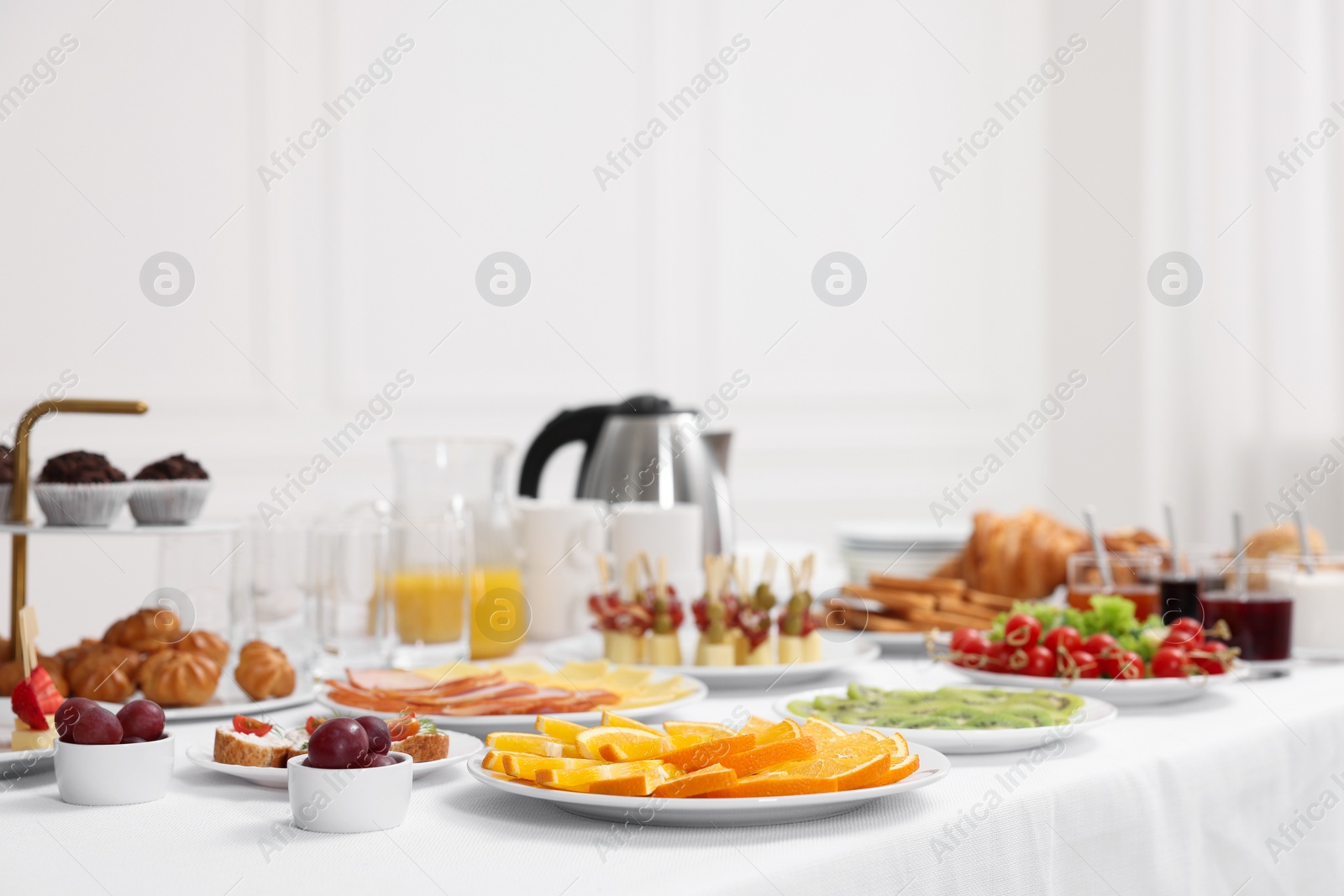 Photo of Different meals served on white table indoors. Buffet menu