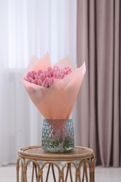 Bouquet of beautiful pink tulips in vase on table indoors