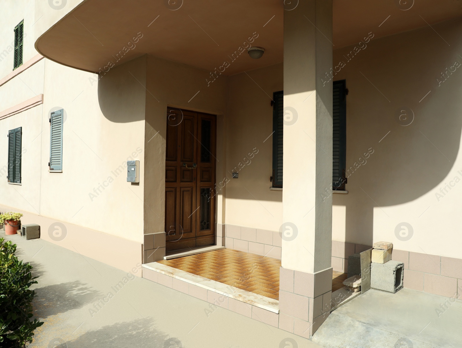 Photo of Beautiful beige building with wooden entrance door on sunny day