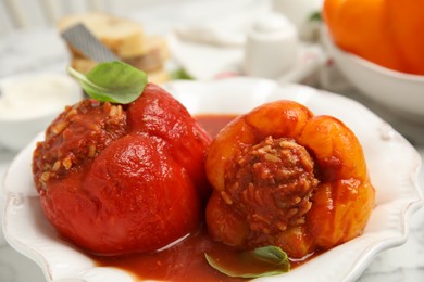 Photo of Delicious stuffed peppers with basil in bowl, closeup