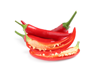 Photo of Cut and whole red hot chili peppers on white background