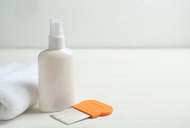 Photo of Comb, anti lice spray and towel on white table. Space for text