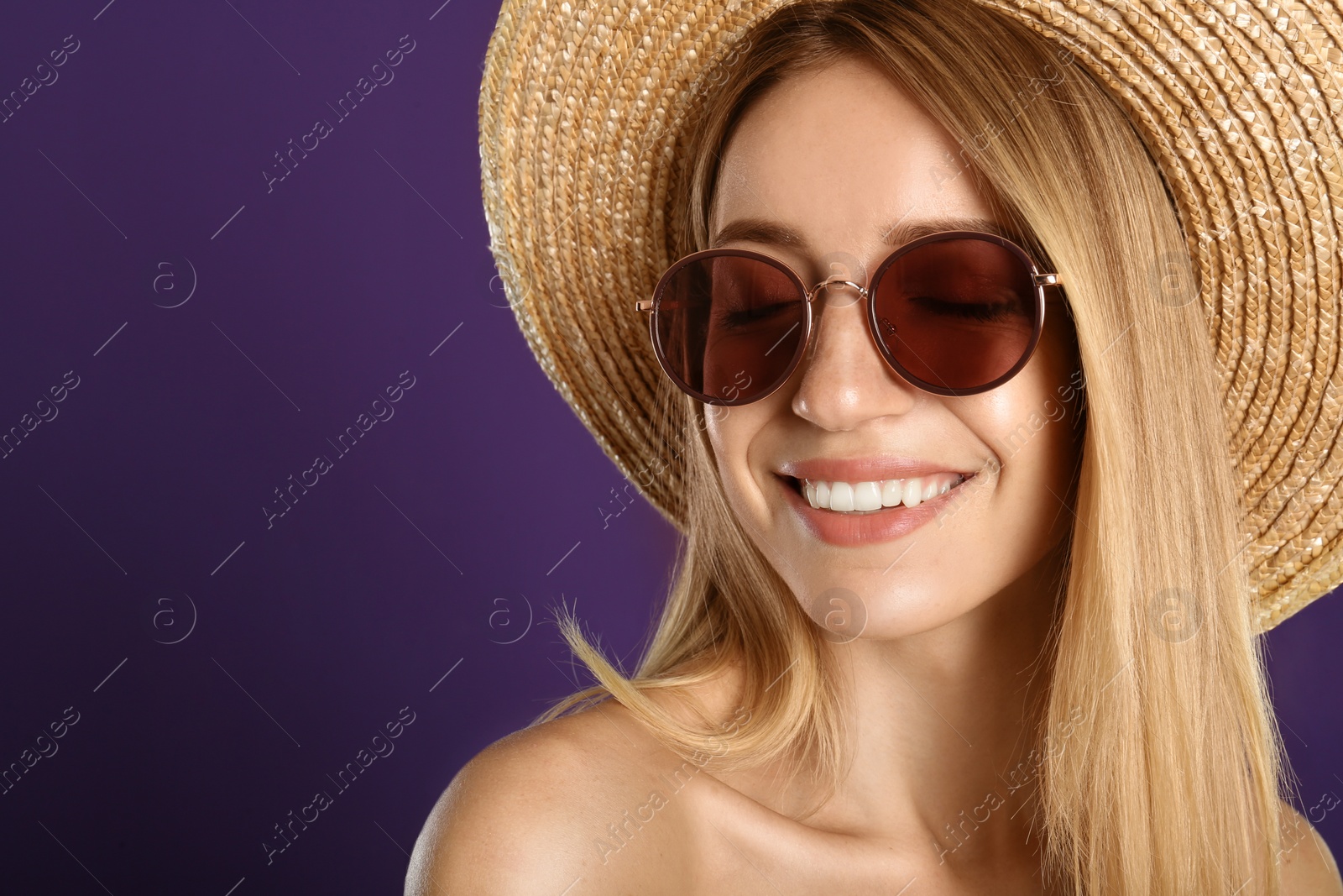 Photo of Beautiful woman in stylish sunglasses on purple background, closeup. Space for text