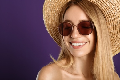 Beautiful woman in stylish sunglasses on purple background, closeup. Space for text