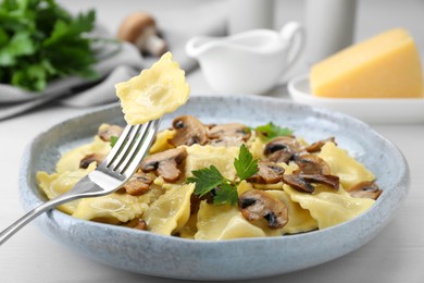 Delicious ravioli with mushrooms and fork on white table, closeup