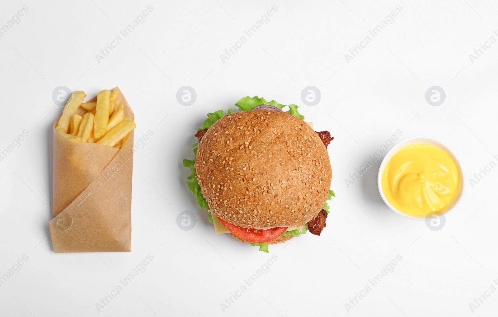 Photo of Tasty burger, french fries and sauce on white background, top view