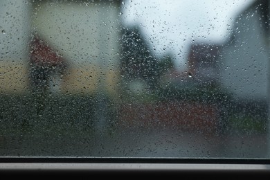 Window glass with water drops, closeup. Rainy weather