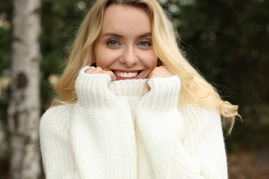 Happy woman in stylish warm sweater outdoors