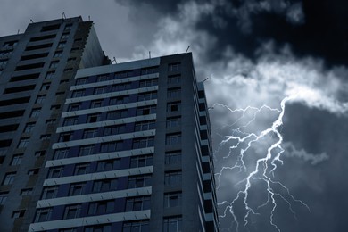Image of Dark cloudy sky with lightning over building. Stormy weather
