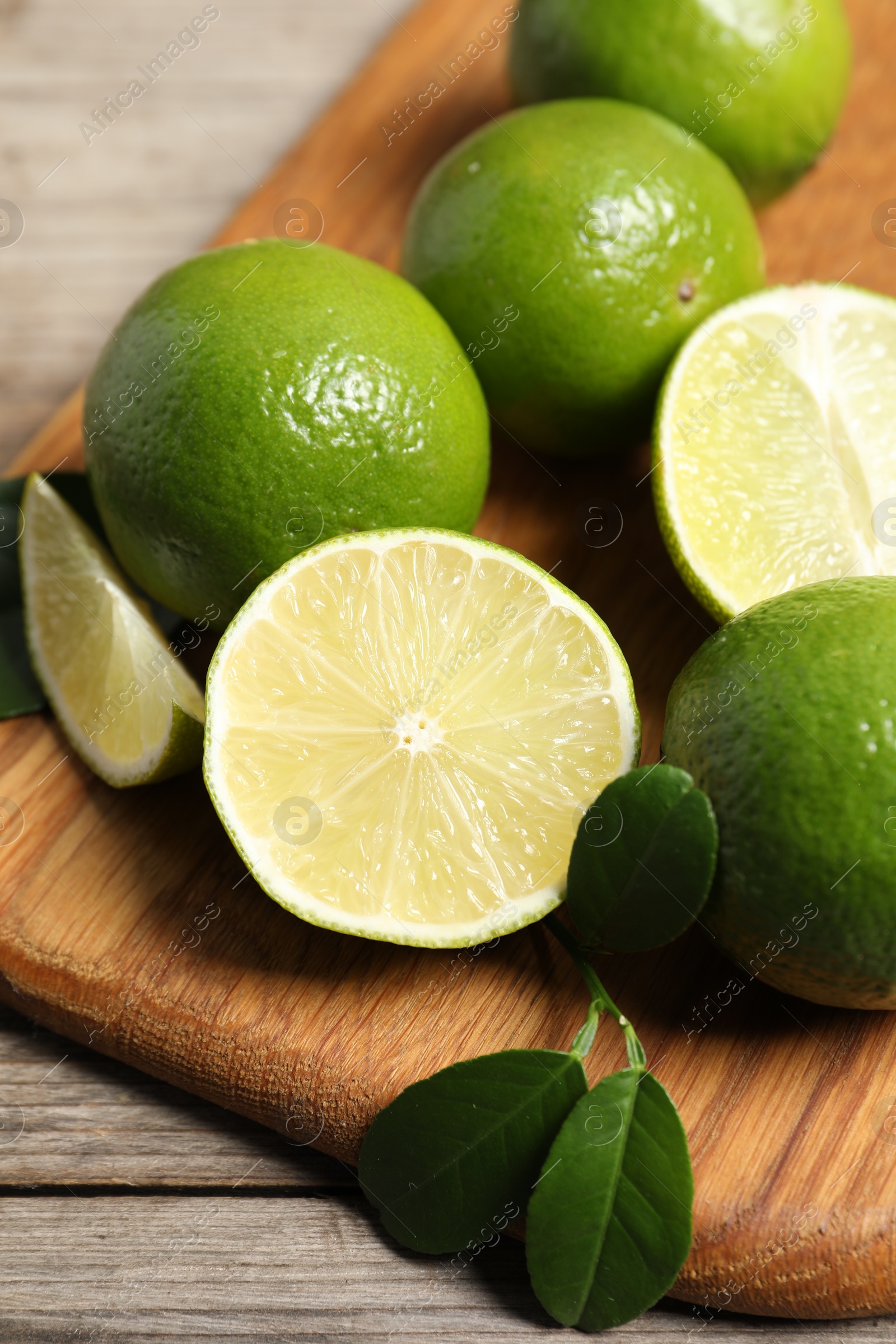 Photo of Fresh ripe limes on wooden table, closeup