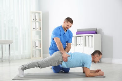 Photo of Doctor working with patient in hospital. Rehabilitation exercises