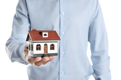 Photo of Real estate agent holding house model on white background