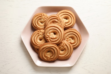 Plate with Danish butter cookies on wooden table, top view