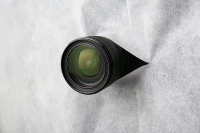 Photo of Hidden camera lens through torn hole in white fabric
