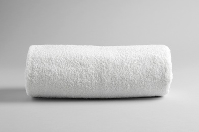 Photo of Fresh soft rolled towel on light background