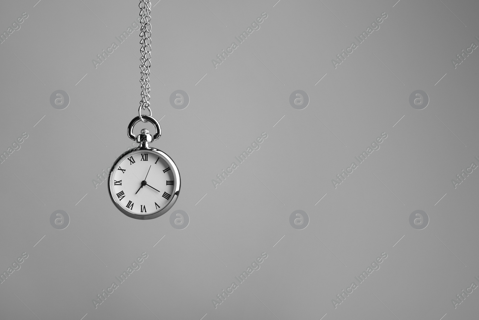 Photo of Stylish pendulum on light grey background, space for text. Hypnotherapy session