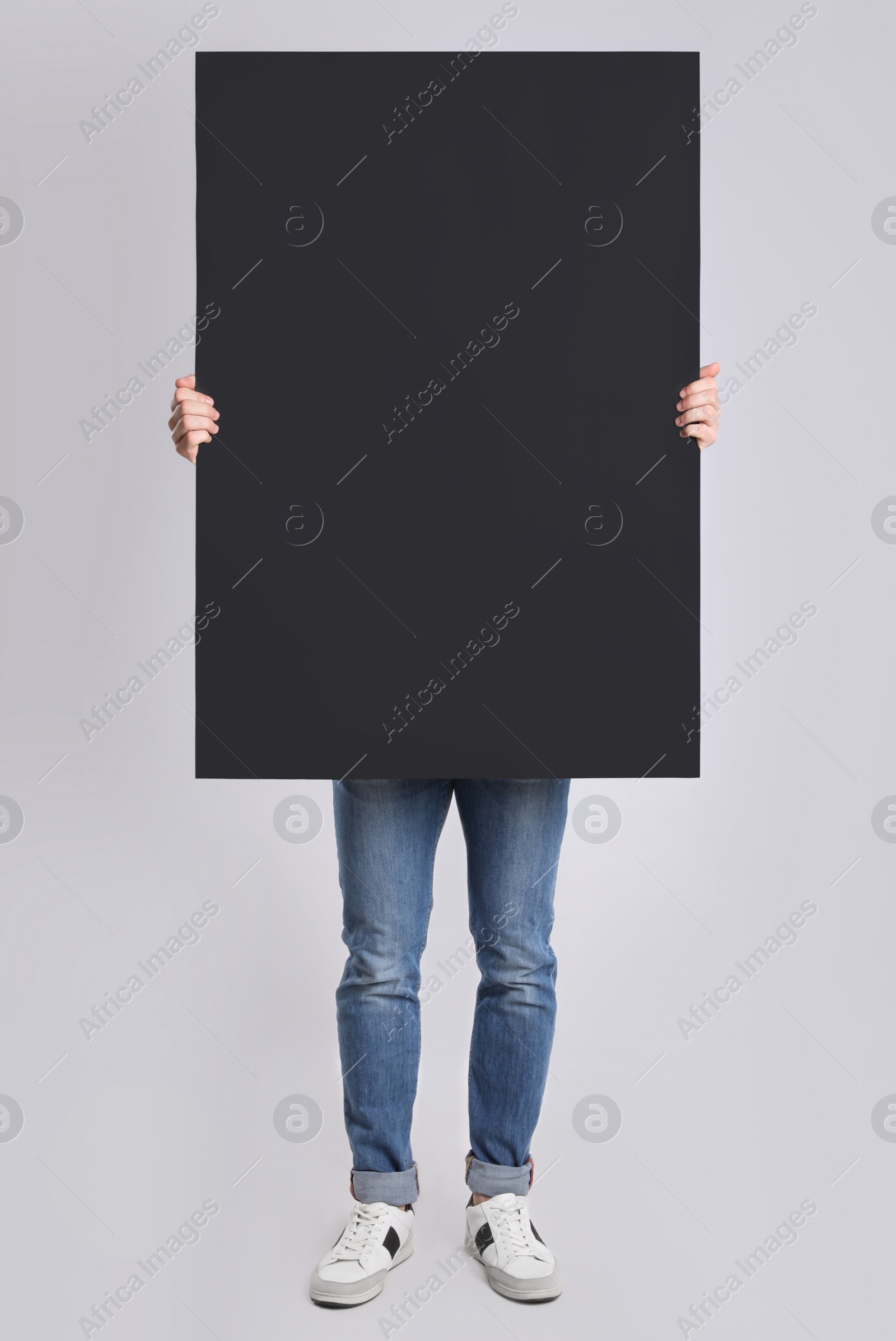 Photo of Man holding blank poster on light grey background
