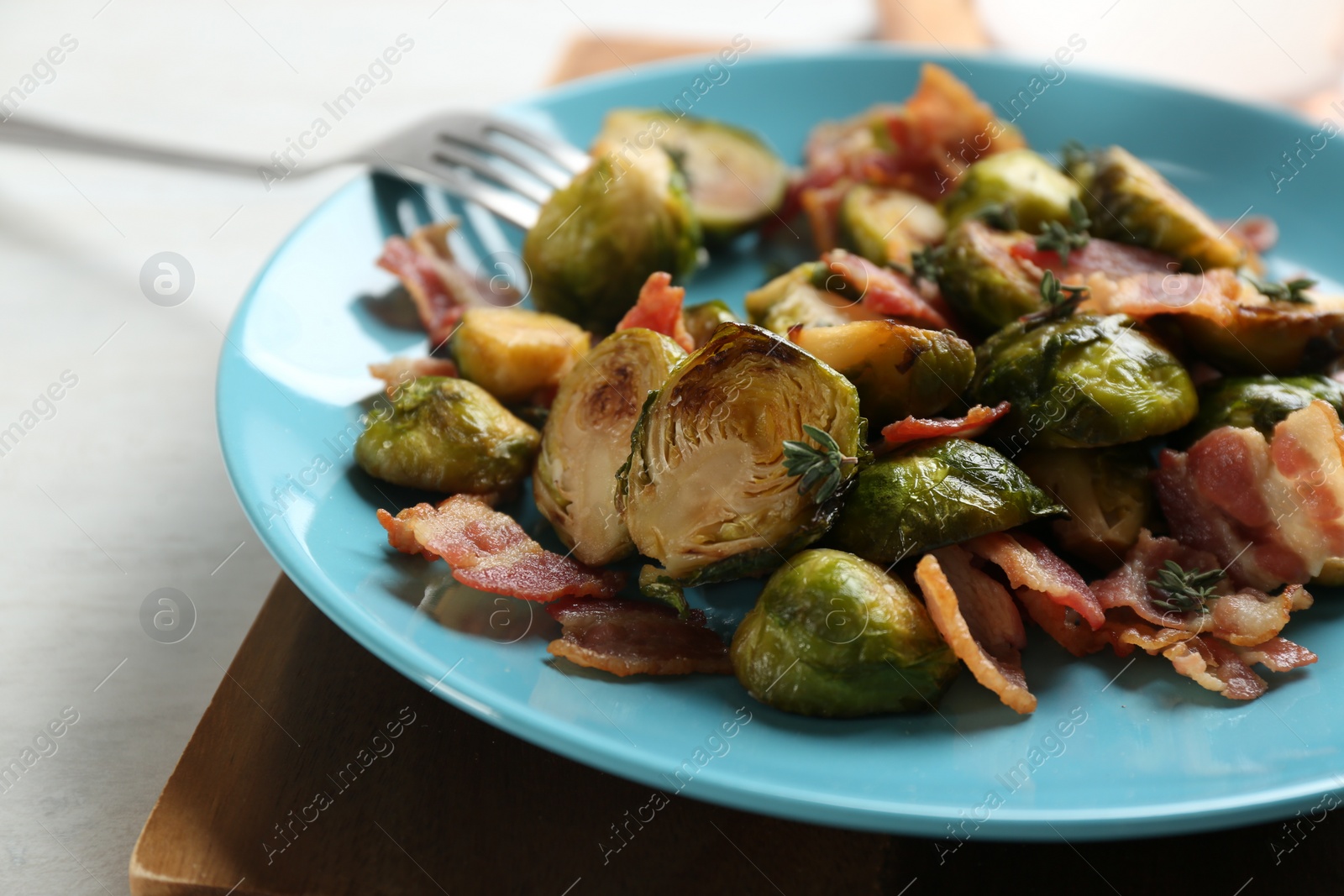 Photo of Roasted brussels sprouts with bacon on plate, closeup