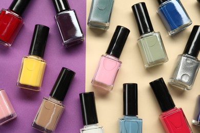 Bright nail polishes in bottles on color background, flat lay