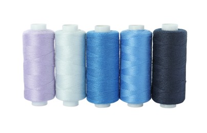 Photo of Set of different colorful sewing threads on white background