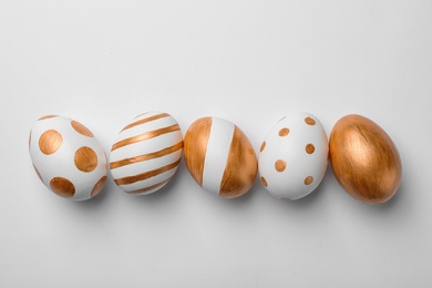 Set of traditional Easter eggs decorated with golden paint on white background, top view