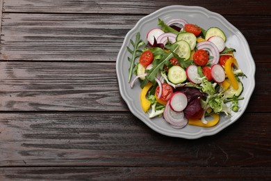 Balanced diet and vegetarian foods. Plate with different delicious products on wooden table, top view. Space for text