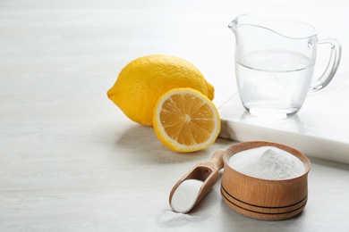 Photo of Composition with baking soda and cut lemons on white wooden table