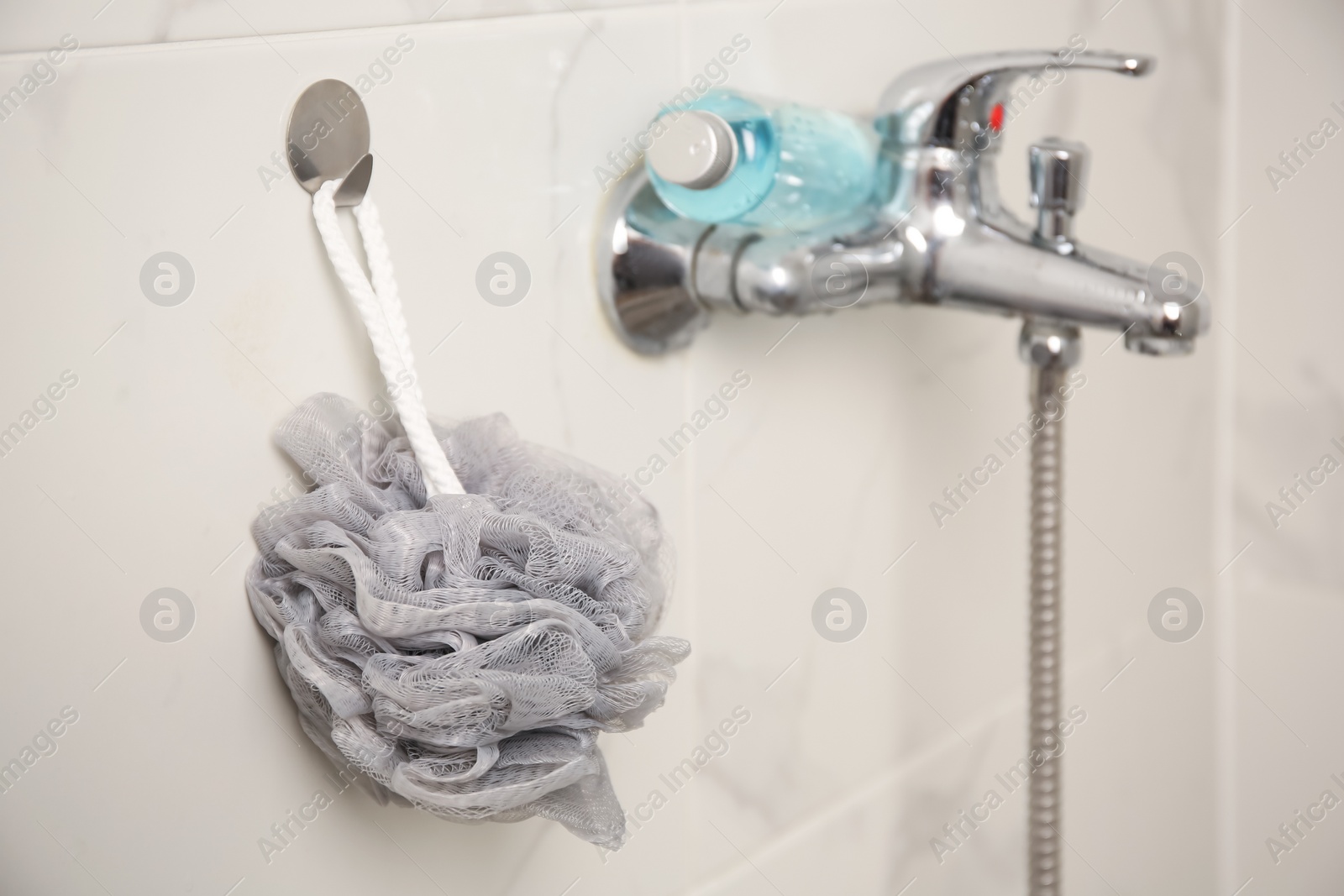 Photo of Grey shower puff and bottle of body wash gel in bathroom