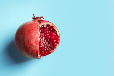 Ripe pomegranate on color background, top view with space for text