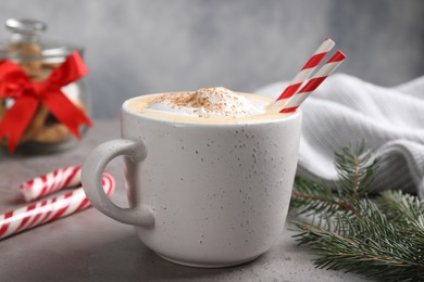 Cup of delicious eggnog with cinnamon on gray table, closeup