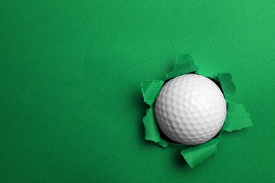 Photo of Torn color paper with golf ball, space for text. Sport equipment