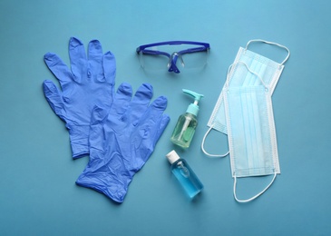 Photo of Flat lay composition with medical gloves, masks and hand sanitizers on blue background