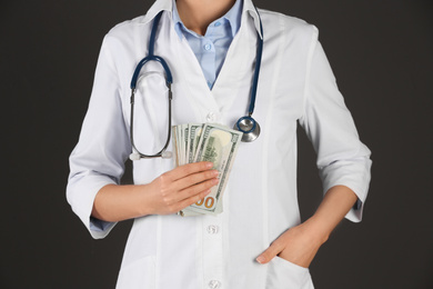 Photo of Doctor with bribe on black background, closeup. Corruption in medicine