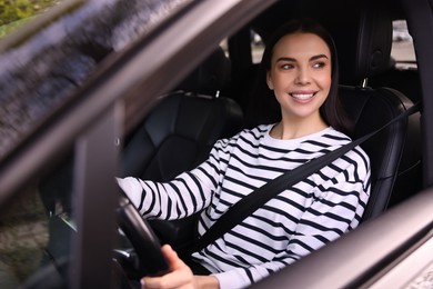 Photo of Woman with safety seat belt driving her modern car