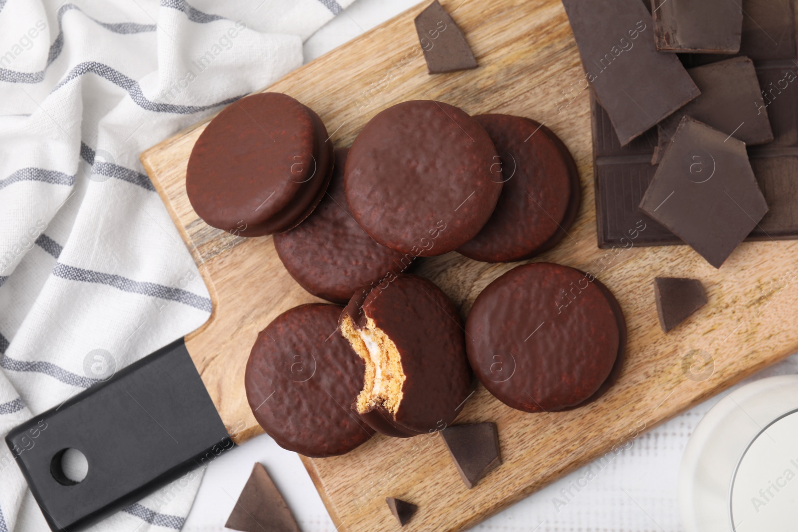 Photo of Tasty choco pies and pieces of chocolate on table, flat lay