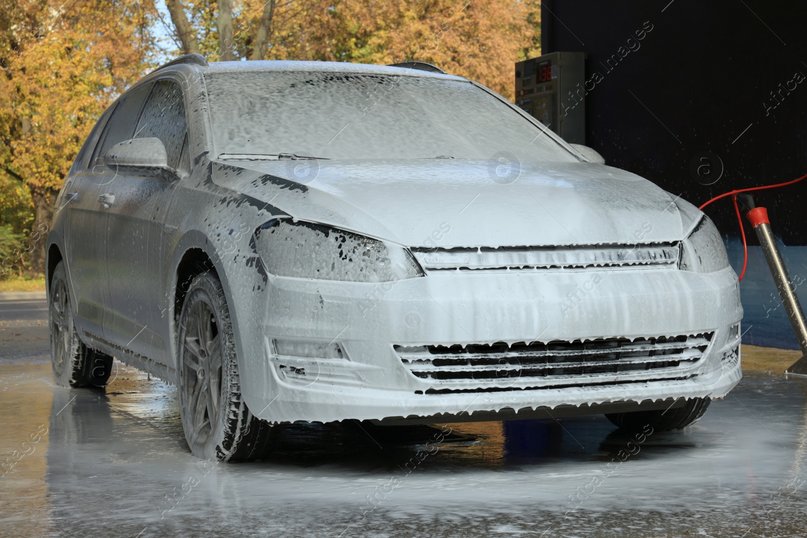 Photo of Auto with cleaning foam at outdoor car wash