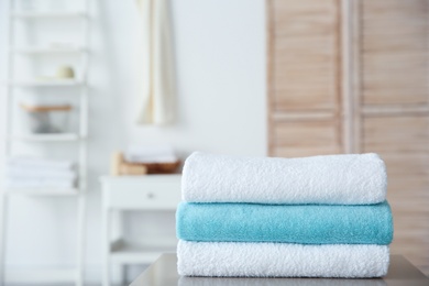 Photo of Stack of towels on table against blurred background