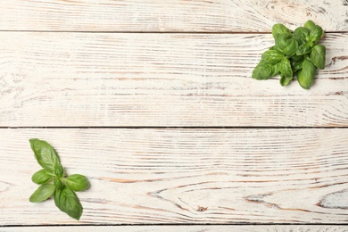 Fresh basil leaves on wooden background, top view. Space for text