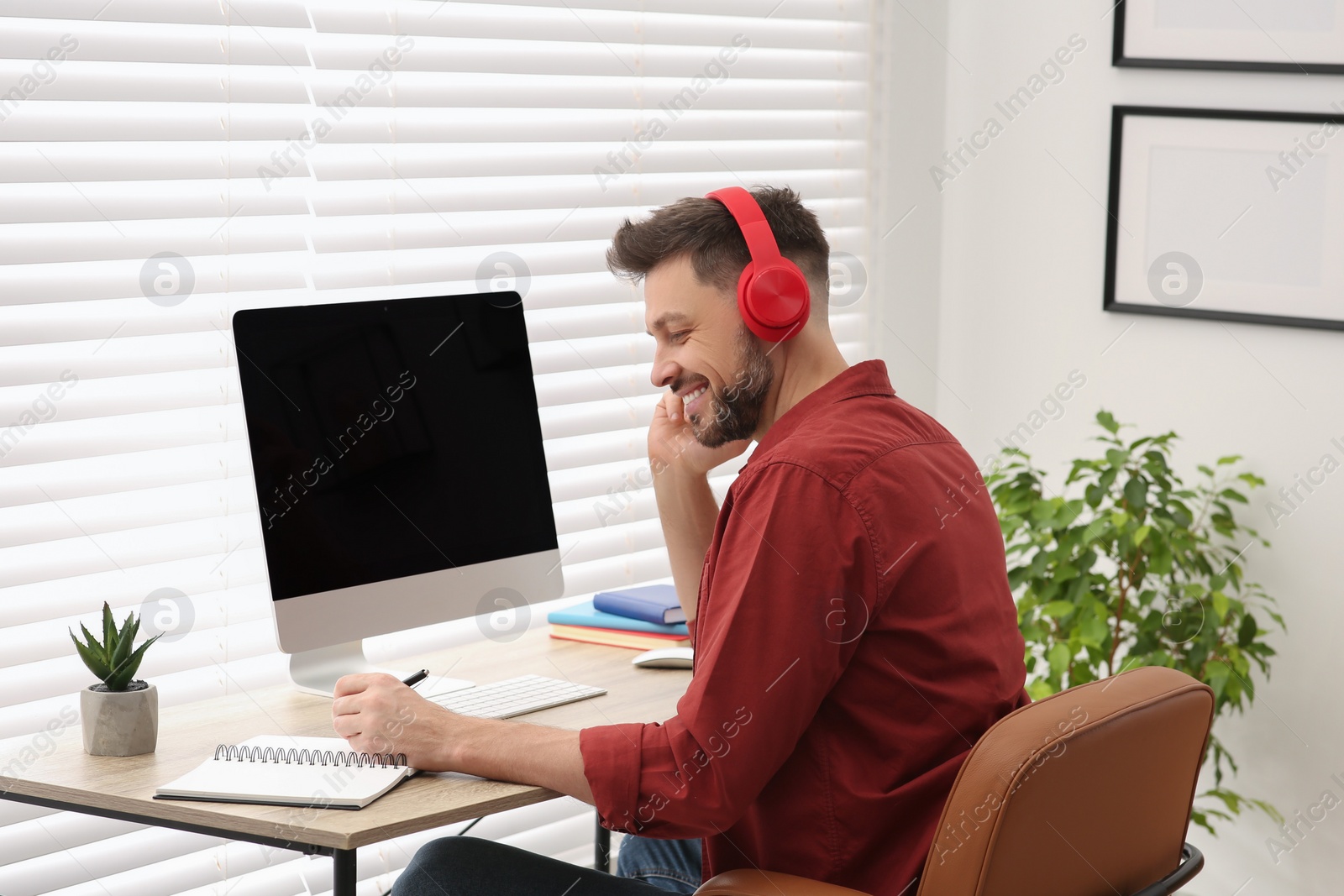 Photo of Man in headphones studying on computer at home. Online translation course