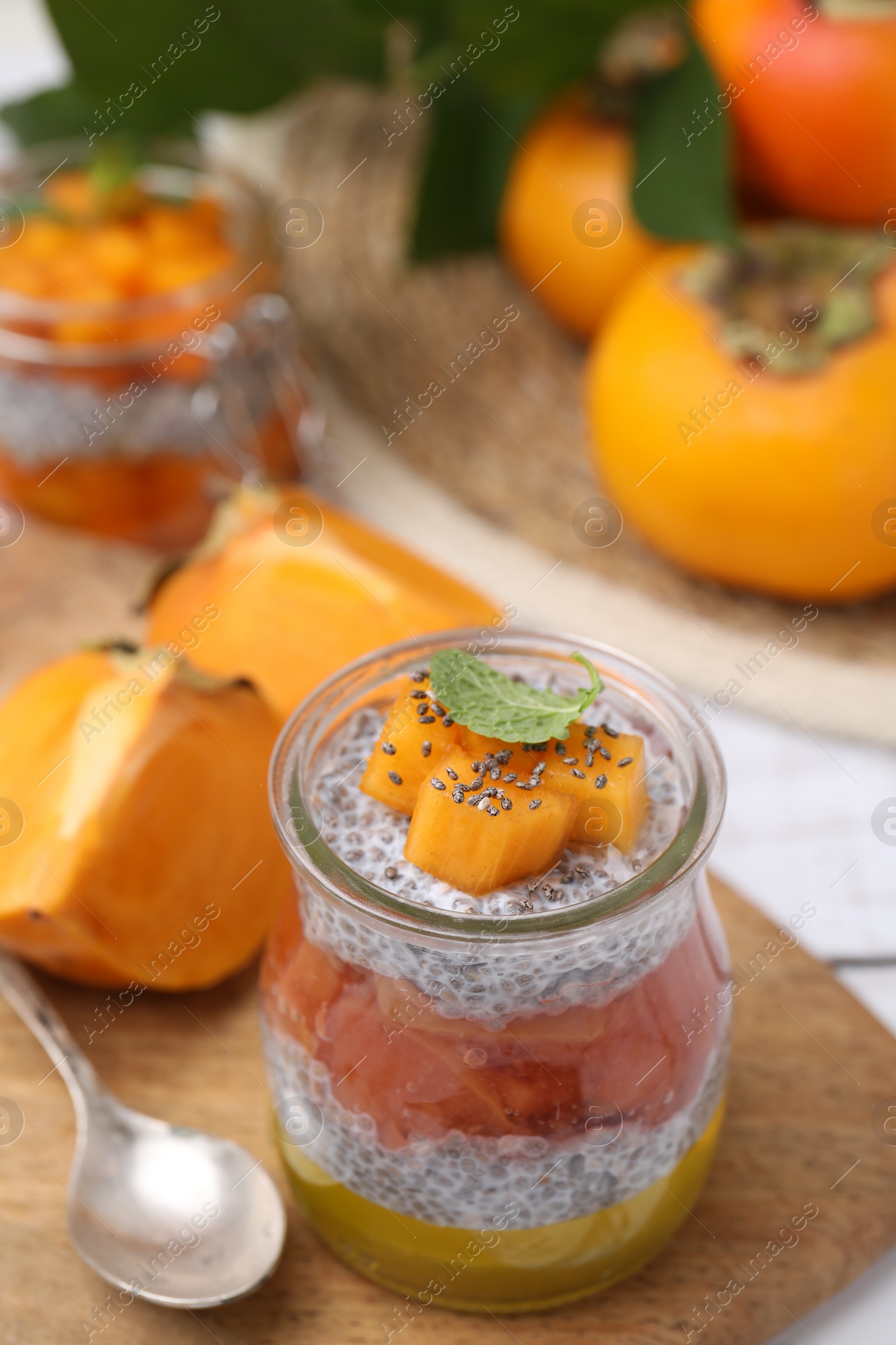 Photo of Delicious dessert with persimmon and chia seeds on table