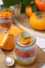 Photo of Delicious dessert with persimmon and chia seeds on table