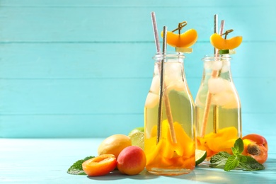 Delicious refreshing drink with apricot on light blue table. Space for text