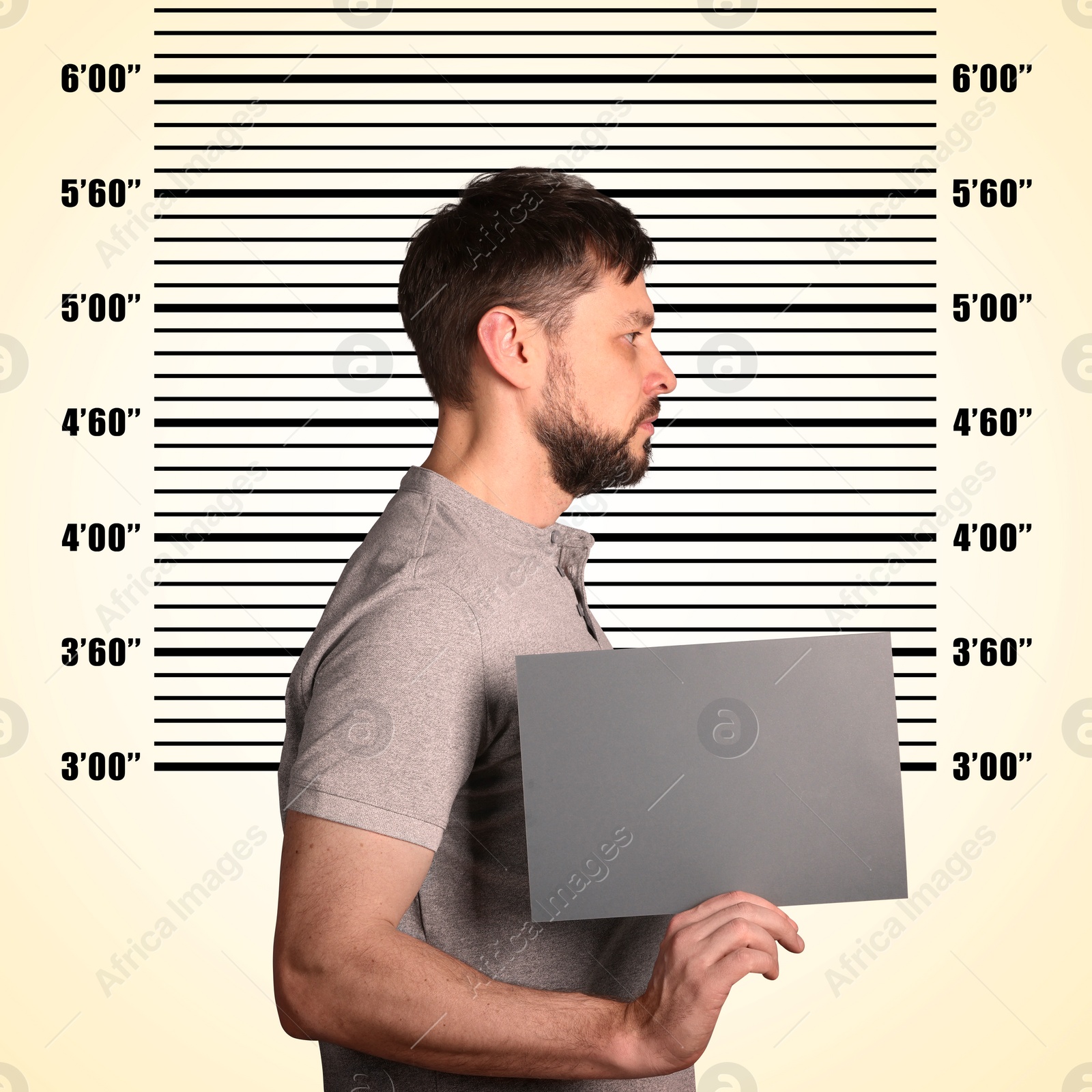 Image of Criminal mugshot. Arrested man with blank card against height chart