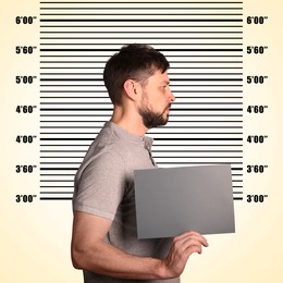 Criminal mugshot. Arrested man with blank card against height chart