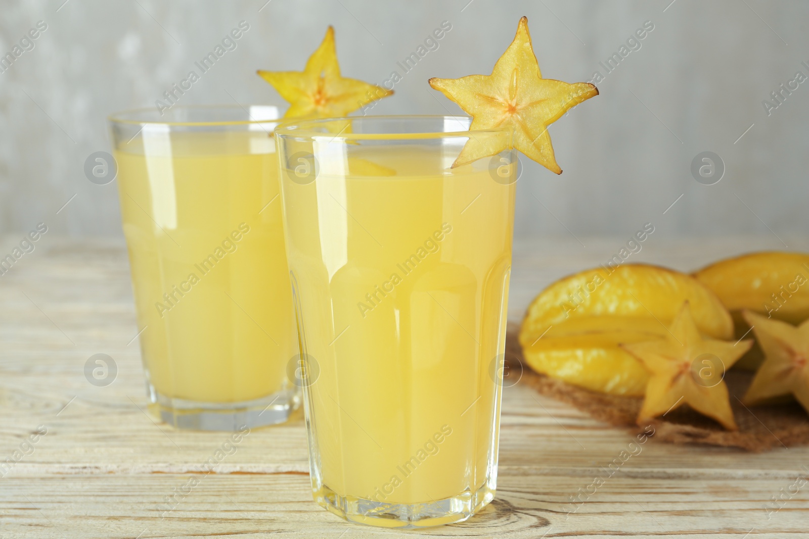 Photo of Delicious carambola juice and fresh fruits on wooden table