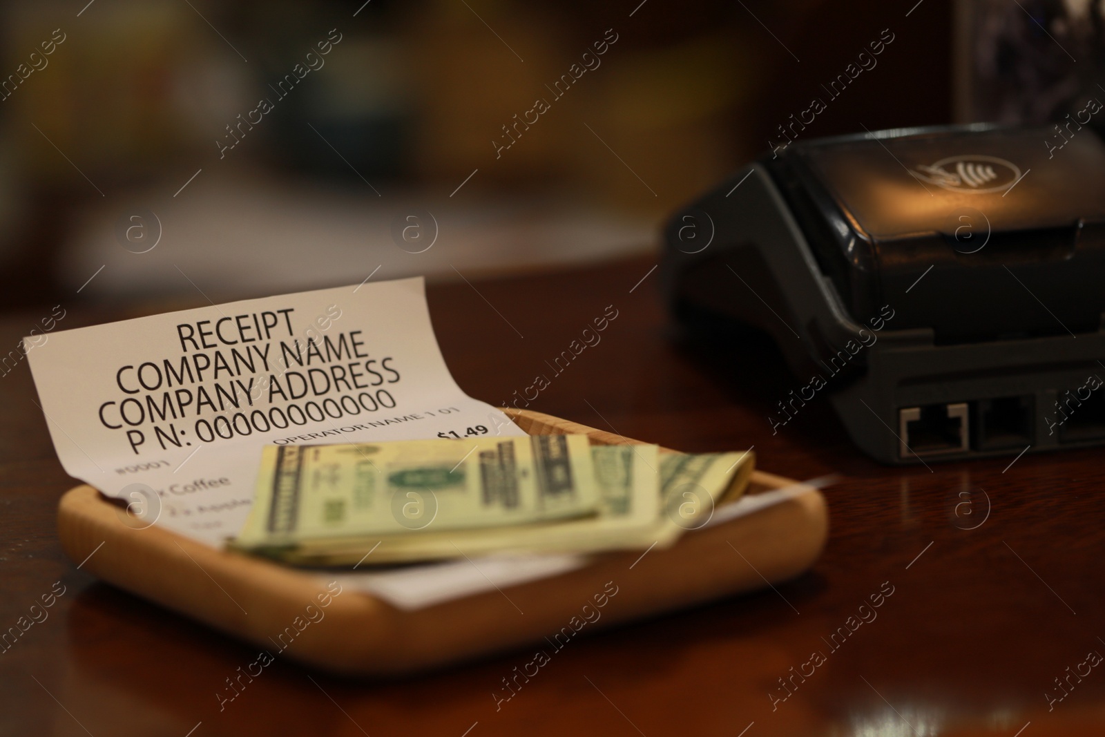 Photo of Tips and receipt on wooden table, closeup