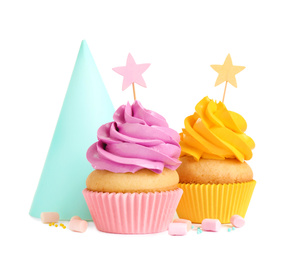 Photo of Delicious birthday cupcakes and party cap on white background