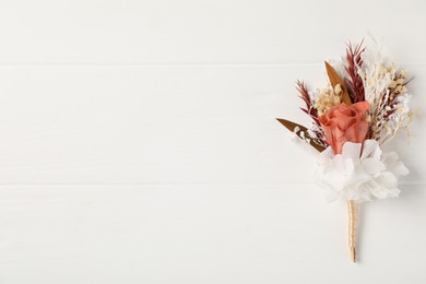 Photo of Beautiful boutonniere on white background, top view. Space for text