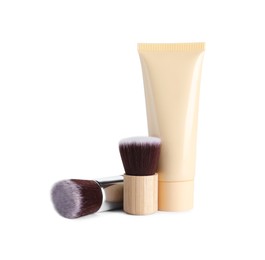 Tube of skin foundation and brushes on white background. Makeup product