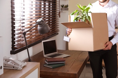 Photo of Businessman with moving box in office, closeup. Work promotion concept